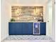 Finished bar area, featuring blue cabinets, a beverage fridge, and wood accent wall at 1559 S Forest St, Denver, CO 80222