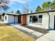 Charming white-brick home showcasing modern design with sleek lines, contrasted by a walkway with rock and stone elements at 1559 S Forest St, Denver, CO 80222