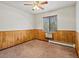A carpeted bedroom with wooden wall trim, a ceiling fan, and a window with blinds at 2800 Kalmia Ave # A310, Boulder, CO 80301