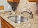 A modern kitchen sink features a chrome faucet, granite countertop, and stylish tile backsplash at 2800 Kalmia Ave # A310, Boulder, CO 80301
