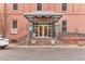 Building entrance with a glass entryway and stairs, set in a brick building with sidewalk and parking at 1143 Auraria Pkwy # 101, Denver, CO 80204