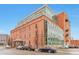 Loft building featuring a brick facade, many windows, and street parking against a vibrant blue sky at 1143 Auraria Pkwy # 101, Denver, CO 80204