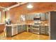 Modern kitchen featuring gray cabinets, stainless steel appliances, granite countertops and brick accent wall at 1143 Auraria Pkwy # 101, Denver, CO 80204
