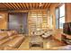 Spacious living room featuring a brick wall, a large bookshelf, and a comfortable seating area at 1143 Auraria Pkwy # 101, Denver, CO 80204