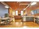 Open loft with a kitchen, dining area, living room, brick walls, exposed beams and a built in bookshelf at 1143 Auraria Pkwy # 101, Denver, CO 80204