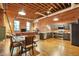Open loft with a kitchen, dining area, living room, brick walls, and exposed beams, filled with natural light at 1143 Auraria Pkwy # 101, Denver, CO 80204