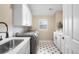Functional laundry room featuring ample cabinet space, a utility sink, and stylish tile flooring at 1214 S Fillmore St, Denver, CO 80210