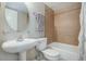 Bathroom featuring tan tile in the shower, a pedestal sink, and white fixtures at 909 N Logan St # 1B, Denver, CO 80203