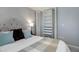 Bedroom with a tufted headboard, plush pillows, neutral walls and a closet with adjustable shelving and drawers at 909 N Logan St # 1B, Denver, CO 80203