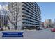 Full exterior shot of The Barrington showcasing its many floors, balconies, mature trees, and surrounding city streets at 909 N Logan St # 1B, Denver, CO 80203