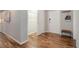 Hallway with wood floors, white doors, coat rack, and bench at 909 N Logan St # 1B, Denver, CO 80203