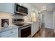 Modern kitchen featuring stainless steel appliances and under-cabinet lighting, with a view towards the hallway at 909 N Logan St # 1B, Denver, CO 80203