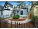 Charming home with well-maintained landscaping, stone pathway, and black metal fence at 161 W Maple Ave, Denver, CO 80223