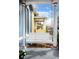 Inviting front porch swing detail with white columns and view of a neighboring home at 161 W Maple Ave, Denver, CO 80223