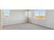 Well-lit bedroom with gray carpeting and multiple windows at 3494 N Irvington St, Aurora, CO 80019