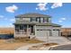 Two-story house with gray siding, brick accents, and a three-car garage at 3494 N Irvington St, Aurora, CO 80019