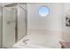 Bright bathroom features a glass shower, soaking tub, and a unique octagon window at 1325 Kingsfield St, Castle Rock, CO 80104