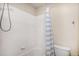Bright bathroom features tiled walls, updated shower head and fixtures, and a blue-striped shower curtain at 1325 Kingsfield St, Castle Rock, CO 80104