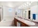 Bright bathroom boasts a dual vanity, soaking tub, shower, and unique octagon window at 1325 Kingsfield St, Castle Rock, CO 80104
