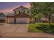 Charming two-story home featuring a stone-accented facade, a well-manicured lawn, and a spacious three-car garage at 1325 Kingsfield St, Castle Rock, CO 80104