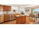 Open kitchen features hardwood floors, stainless steel appliances, and breakfast nook at 1325 Kingsfield St, Castle Rock, CO 80104