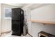 Efficient laundry room features a stacked washer and dryer unit and storage shelving at 1325 Kingsfield St, Castle Rock, CO 80104
