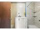Bathroom with white vanity, black fixtures, and neutral tile and shower stall at 12 Marshall Pl, Longmont, CO 80504