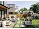 Manicured backyard featuring an outdoor living area, stone pavers, and mature trees at 1130 S Cook St, Denver, CO 80210