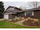 Charming home featuring a brick facade, well-manicured garden, and attached garage for convenient parking at 8229 Estes Ct, Arvada, CO 80005