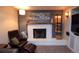 Cozy living room featuring a white brick fireplace, leather seating, and stylish decor at 8229 Estes Ct, Arvada, CO 80005
