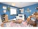 Blue living room featuring indoor plants and a vintage rug at 8229 Estes Ct, Arvada, CO 80005