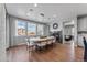 Bright dining room features hardwood floors, modern lighting, and a sleek fireplace with large windows providing abundant light at 16320 W 92Nd Cir, Arvada, CO 80007
