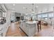 Open kitchen featuring a large island with seating and modern appliances with views of the living space at 16320 W 92Nd Cir, Arvada, CO 80007