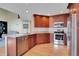 Well-lit kitchen with stainless steel appliances, granite countertops, and wooden floors at 2649 S Kline Cir, Lakewood, CO 80227