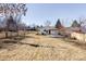 Spacious backyard with mature trees and a partially covered patio at 11825 W 25Th Ave, Lakewood, CO 80215