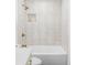 Bright bathroom featuring a shower with white vertical tile and gold fixtures at 11825 W 25Th Ave, Lakewood, CO 80215
