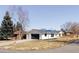 Exterior shot of a white home with a dark roof and a two car garage at 11825 W 25Th Ave, Lakewood, CO 80215