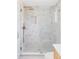 Modern shower featuring neutral toned tiling, rainfall shower head, and glass door at 11825 W 25Th Ave, Lakewood, CO 80215