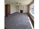Spacious living room with a fireplace, plush carpet, and natural light streaming through the windows at 1062 Timbervale Trl, Highlands Ranch, CO 80129