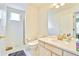 Bright bathroom featuring white cabinets, a large mirror, and a separate shower with glass door at 1011 S Valentia St # 147, Denver, CO 80247