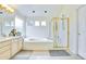 Bright bathroom with double sink vanity, soaking tub, and glass-enclosed shower, perfect for relaxation and convenience at 1011 S Valentia St # 147, Denver, CO 80247