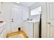 Functional laundry room with modern washer and dryer, ample counter space, and wood floors at 1011 S Valentia St # 147, Denver, CO 80247