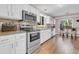 Bright, modern kitchen featuring stainless steel appliances, white cabinets, and a mosaic backsplash at 4279 Brandon Ave, Broomfield, CO 80020