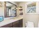Bathroom featuring a sleek vanity with modern fixtures, a large mirror, and ample natural light for a refreshing experience at 1927 Sunset Cir, Evergreen, CO 80439