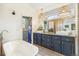 Well-lit bathroom with double vanity, modern fixtures, and a stylish bathtub for a relaxing and spa-like experience at 1927 Sunset Cir, Evergreen, CO 80439