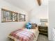 Small bedroom with a twin bed, a view to the outside and wood trim creating a cozy and inviting space at 1927 Sunset Cir, Evergreen, CO 80439
