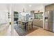 Bright open concept kitchen and dining room area with stainless fridge and wood floors at 1927 Sunset Cir, Evergreen, CO 80439