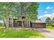 Two-story home with brown wood siding, attached garage, and surrounding aspen trees at 1927 Sunset Cir, Evergreen, CO 80439