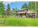 Wide angle of a charming two-story home with a large backyard and covered deck at 1927 Sunset Cir, Evergreen, CO 80439