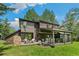 Exterior of a two-story home with a large deck, hot tub, and outdoor seating areas at 1927 Sunset Cir, Evergreen, CO 80439
